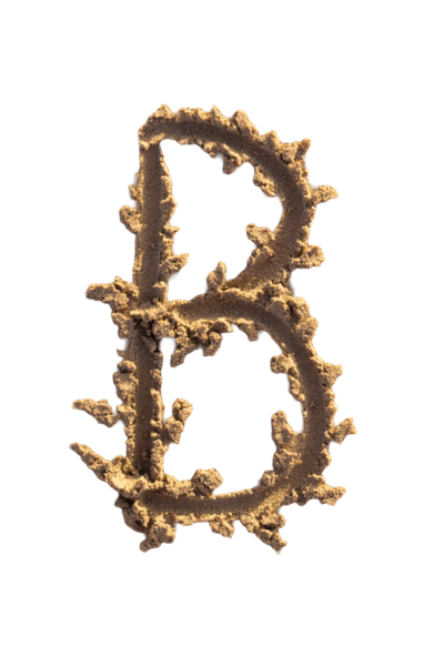 Alfabe (B) harfleri kumsalda el yazısıyla yazılmış.