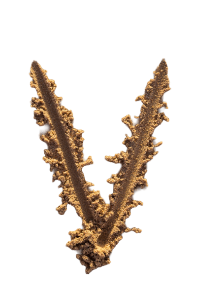 Alfabe (V) harfleri kumsalda el yazısıyla yazılmış.