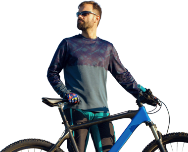 Şortlu ve formalı bisikletçi, modern karbon kuyruklu motorsikletli. Uçurumun kenarında, yeşil bahar ormanlarının arka planında duran bir hava süspansiyon çatalı var.