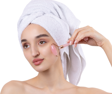 Kalın kaşlı güzel bir kız, beyaz arka planda mükemmel bir ten, kafasında havlu, güzel bir fotoğraf. Kozmetik rulo tutuyor..