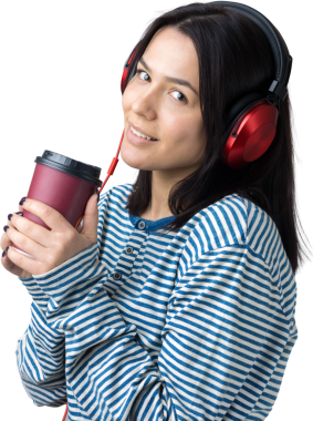 Çizgili yelek giymiş genç bir kız stüdyoda kırmızı kulaklıkla müzik dinliyor ve dans ediyor..