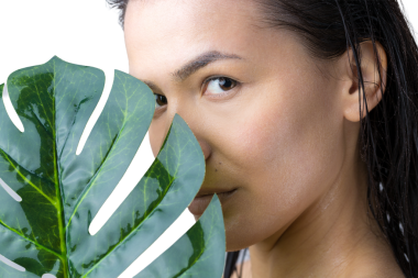 Doğal yeşil palmiye yaprağı portresi olan bir kadın. Moda, güzellik, makyaj, kozmetik.