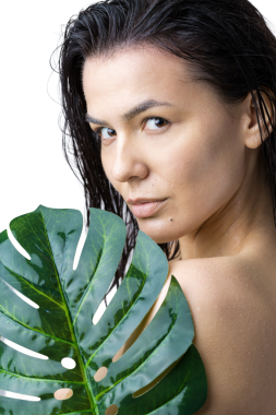 Doğal yeşil palmiye yaprağı portresi olan bir kadın. Moda, güzellik, makyaj, kozmetik.
