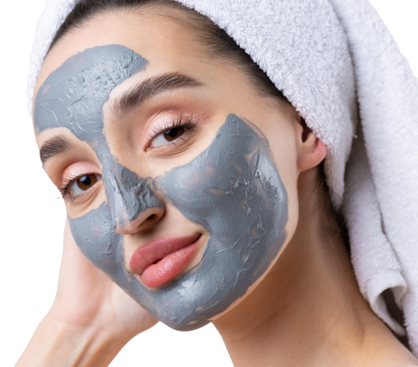 Kafasında beyaz bir havluyla beyaz arka planda gri bir kozmetik maskesi olan bir kadın..