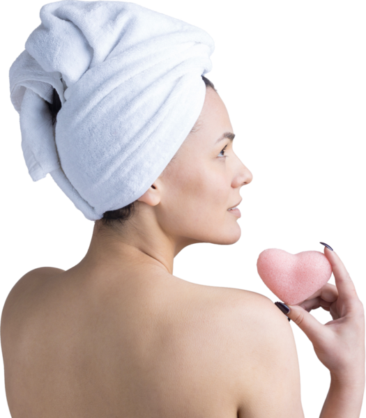 Kafasında beyaz havluyla güzel bir kadın portresi ve pembe bir kalbe bakan bir vücut için sünger. Cilt temizleme eko organik kozmetik rahatlama konsepti.