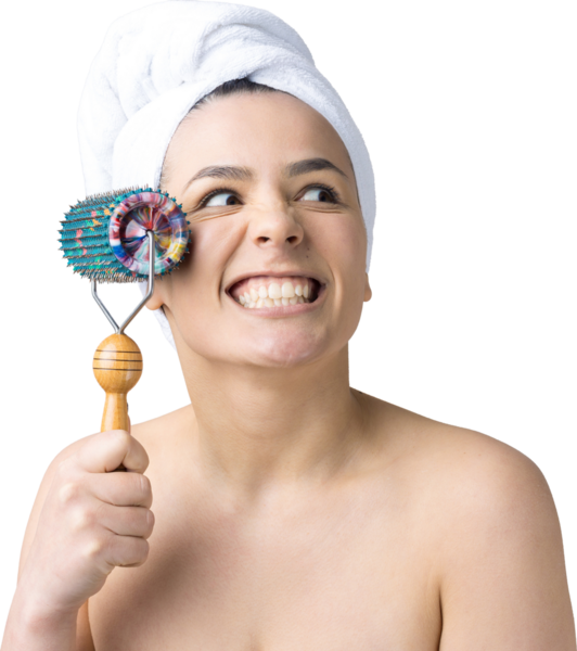 Kafasında havlu olan esmer, gri arka planda izole edilmiş yüz masajı için silindir kullanıyor.