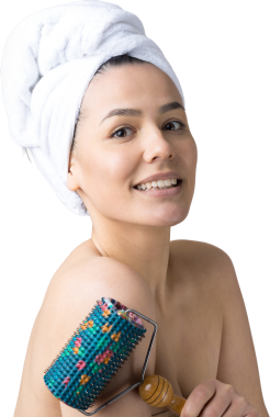 Kafasında havlu olan esmer, gri arka planda izole edilmiş yüz masajı için silindir kullanıyor.