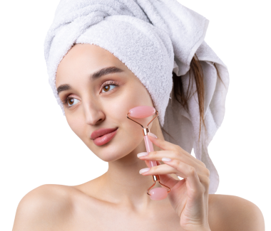 Kalın kaşlı güzel bir kız, beyaz arka planda mükemmel bir ten, kafasında havlu, güzel bir fotoğraf. Kozmetik rulo tutuyor..