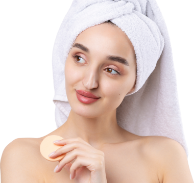 Kalın kaşlı güzel bir kız, beyaz arka planda mükemmel bir ten, kafasında havlu, güzel bir fotoğraf. Kozmetik sünger tutuyor..