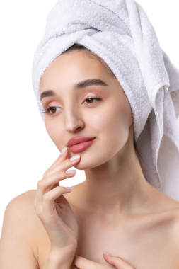 Kalın kaşlı güzel bir kız, beyaz arka planda mükemmel bir ten, kafasında havlu, güzel bir fotoğraf..