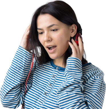 Çizgili yelek giymiş genç bir kız stüdyoda kırmızı kulaklıkla müzik dinliyor ve dans ediyor..