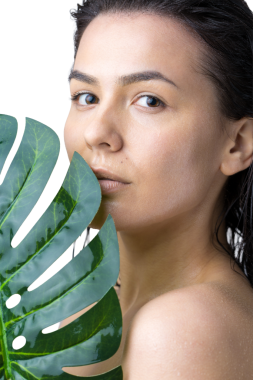 Doğal yeşil palmiye yaprağı portresi olan bir kadın. Moda, güzellik, makyaj, kozmetik.