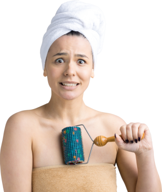 Kafasında havlu olan esmer, gri arka planda izole edilmiş yüz masajı için silindir kullanıyor.