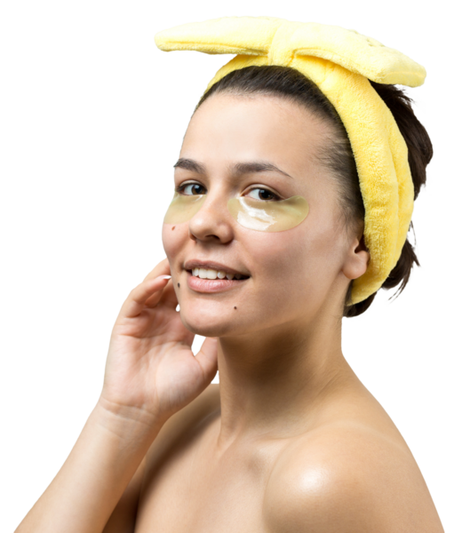 Kafasında beyaz havluyla gezen genç bir kız gözlerinin altına kolajen jel bantlar takıyor. Göz teması altında maske.