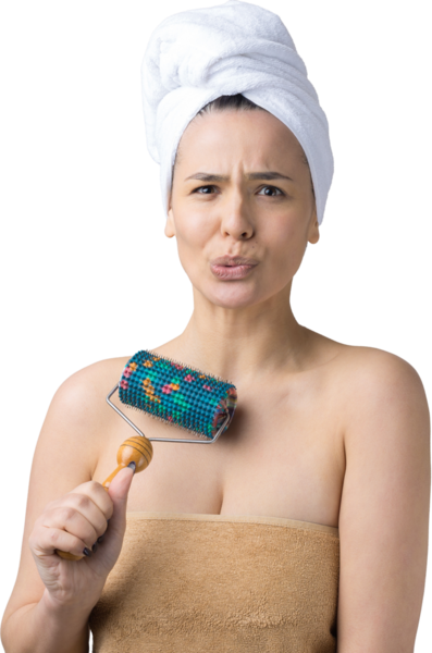 Kafasında havlu olan esmer, gri arka planda izole edilmiş yüz masajı için silindir kullanıyor.