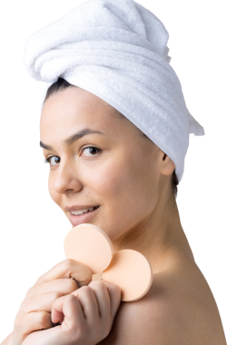 Kafasında beyaz havluyla güzel bir kadın portresi ve pembe bir kalbe bakan bir vücut için sünger. Cilt temizleme eko organik kozmetik rahatlama konsepti.