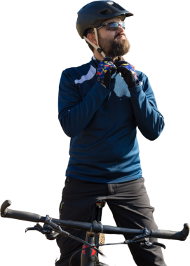 Pantolon ve yün ceketli bir bisikletçi modern karbon donanımlı bir motorsikletle off-road 'a biniyor. Adam sonbahar parkında bir bankta dinleniyor..