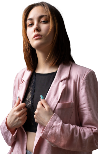 Kız pembe bir ceket ve stüdyoda gri bir kanepede siyah bir bluz giymiş..