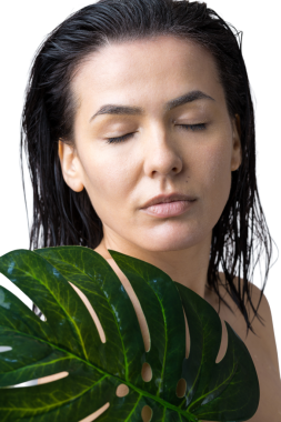 Doğal yeşil palmiye yaprağı portresi olan bir kadın. Moda, güzellik, makyaj, kozmetik.