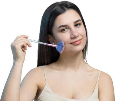 Açık renk bluzlu, beyaz arka planda yüz makyajı yapan genç bir kızın yakın çekimi. Güzel bir kadın yüzüne bir makyaj fırçası tutar ve gülümser..