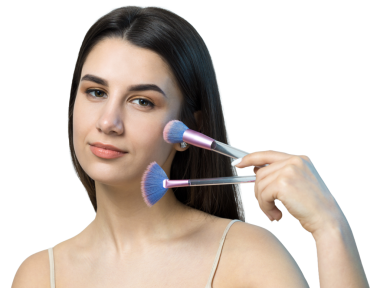 Açık renk bluzlu, beyaz arka planda yüz makyajı yapan genç bir kızın yakın çekimi. Güzel bir kadın yüzüne bir makyaj fırçası tutar ve gülümser..