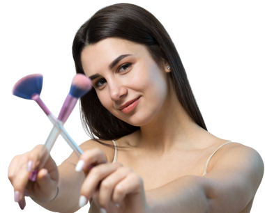 Açık renk bluzlu, beyaz arka planda yüz makyajı yapan genç bir kızın yakın çekimi. Güzel bir kadın yüzüne bir makyaj fırçası tutar ve gülümser..