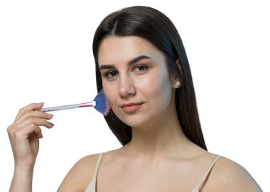 Açık renk bluzlu, beyaz arka planda yüz makyajı yapan genç bir kızın yakın çekimi. Güzel bir kadın yüzüne bir makyaj fırçası tutar ve gülümser..