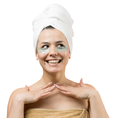 Kafasında beyaz havluyla gezen genç bir kız gözlerinin altına kolajen jel bantlar takıyor. Göz teması altında maske.