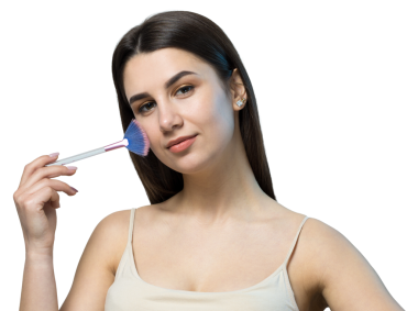 Açık renk bluzlu, beyaz arka planda yüz makyajı yapan genç bir kızın yakın çekimi. Güzel bir kadın yüzüne bir makyaj fırçası tutar ve gülümser..