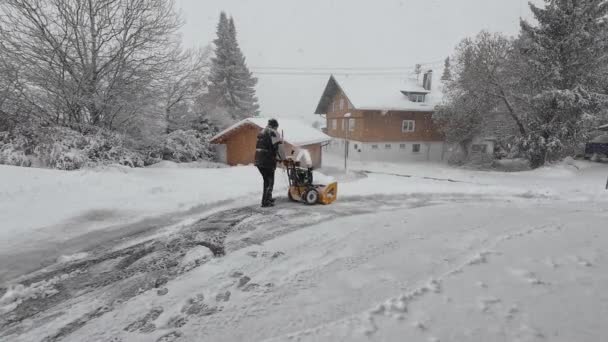 雪が降る冬の日に 男は雪を掃除しています — ストック動画
