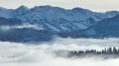 Kışın dağların önündeki vadide sis varken insansız hava aracı videosu.