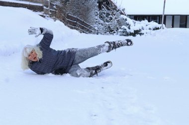 Kışın kaygan bir yolda kayma riski. Bir kadın kayıp kara düşmüş.