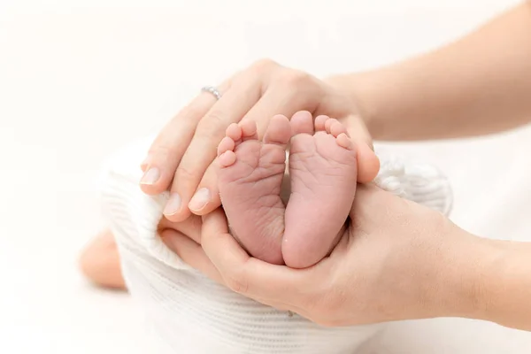 両親の腕の中の赤ちゃんの足は — ストック写真