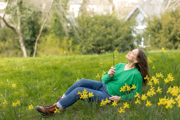 Uma Mulher Meia Idade Relaxa Parque Com Narcisos Flor Imagem De Stock