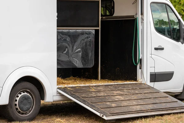 Horse box cargo trailer transport with open tailgate with hay and manure and horse transportation van at farm or ranch. Horsebox carriage lorry animal livestock tranport haulage.