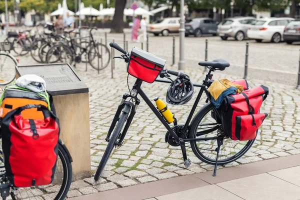 Many modern bicycles with travel luggage bags equipment parked in old european city center street. Healthy eco sustainable tourism family trip lifestyle. Bike hobby adventure tour journey.