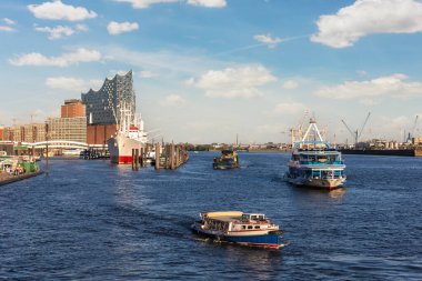 Hansestadt Hamburg Elbe limanının panoramik manzarası ve sıcak günbatımında Elbphilarmonie konser salonu. Hamburg hafencity Speicherstadt şehir manzarası gezisi.