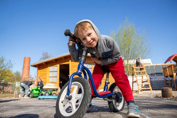 可爱可爱可爱的高加索幼儿男孩肖像画 在公园或庭院花园的森林里玩乐地骑着平衡跑车推摩托车 儿童第一自行车 儿童户外运动夏季活动 — 图库照片