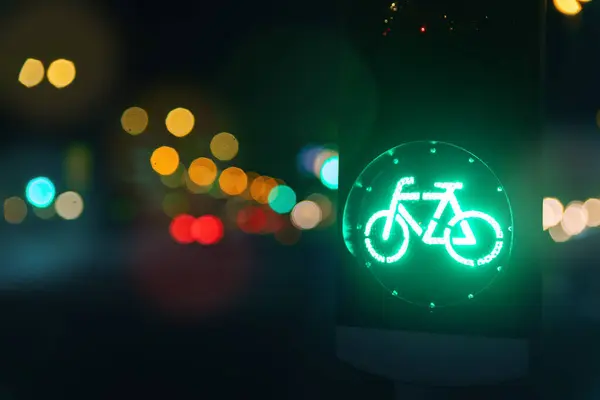 Bicycle green allowing lamp sign on traffic light road highway driveway drive crossroad intersection evening dark time german city. Bike forward movement safe on semaphore signal city street.