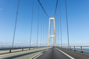 Great Belt ya da Sealand Funen 'dan East Bridge Storebaelt Danimarka adasının açık gökyüzü geçmişi. Güneşli bir günde asma köprü inşaatı. Avrupa seyahat ulaşımı.