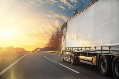 Tail view beyaz boş modern teslimat büyük kargo kargo ticari karavan taşımacılık otoyol şehir banliyösü. İş dağıtım lojistik servisi. Kamyon süren gün batımı.