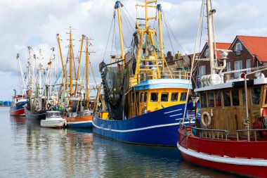Renkli eski Alman balıkçı tekneleri Neuharlingersiel limanı Wadden denizi Doğu Frizya Kuzey Almanya 'ya demirlemişti. Ticari balık yengeci karides trol ağları Kuzey Denizi küçük liman şehri.