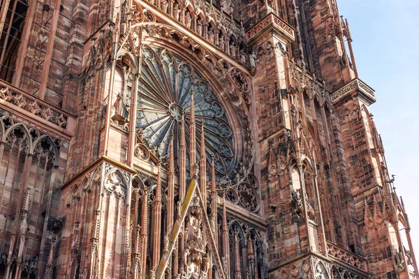Close-up view of Cathedrale Notre Dame de Strasbourg in France Strasbourg city. Detail gothic architecture rose window stained glass facade wall of medieval historic church Alsace town sunny sky day.