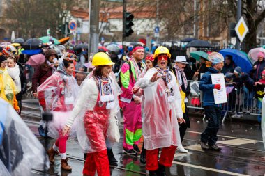 Erfurt, Almanya - 11 Şubat 2024: Geleneksel Alman Karnavalı Fasching 2024, Thüringen. İnsanlar şehir sokaklarında festival dansını kutluyor. Şiddetli yağmur altında yüzen şehir merkezinde eğleniyorlar..