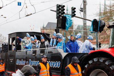 Erfurt, Almanya - 11 Şubat 2024: Geleneksel Alman Karnavalı Fasching 2024, Thüringen. İnsanlar şehir sokaklarında festival dansını kutluyor. Şiddetli yağmur altında yüzen şehir merkezinde eğleniyorlar..