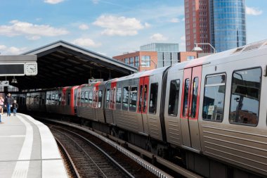 Hamburg Red Unmanned U-bahn Metro tren istasyonu Yükseltilmiş Pist 'teki Baumwall tren istasyonu Hamburger Limanı Elbphilharmonie bina arka plan mavi gökyüzü. Hanseatik şehri ulaşım manzaralı.