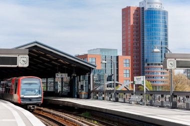 Hamburg Red Unmanned U-bahn Metro tren istasyonu Yükseltilmiş Pist 'teki Baumwall tren istasyonu Hamburger Limanı Elbphilharmonie bina arka plan mavi gökyüzü. Hanseatik şehri ulaşım manzaralı.