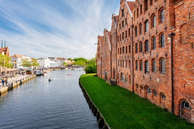 Scenic view panorama Lubeck hanseatic city blue sky sunny summer day. Travemunde Trave river embankment in Lubeck historic Holstentor museum Salzspeicher building in medieval town altstadt Germany. clipart