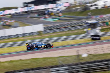 Oschersleben, Almanya, 28 Nisan 2024: Sahne hareket bulanıklığı hızlı FK Motorsport BMW M4 GT3 DTM ADAC GT Masters Oschersleben Motorsport yarış pisti. Avrupa otomobil sporları yarışması.