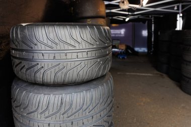 Spor yarış lastikleri, motor sporları pistinin çukur alanına yerleştirilmeye hazır. Spor araba hız pisti asfalt yarışması için birikmiş spor lastikleri.